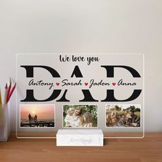 an acrylic photo frame with the words, we love you dad and photos