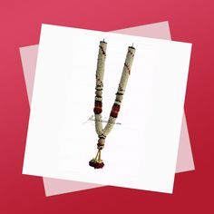 a long beaded necklace with red and white beads hanging from it's end