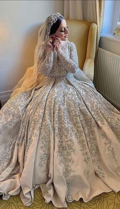 a woman sitting in a chair wearing a wedding dress