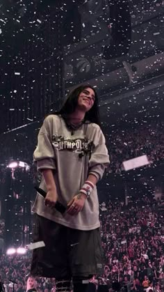 a woman standing on top of a stage with confetti falling from the air