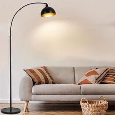 a living room with a couch, lamp and basket on the floor in front of it