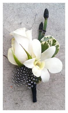 a bouquet of flowers sitting on top of a cement floor next to two green stems