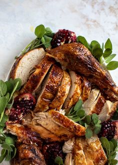 a white plate topped with meat covered in cranberry sauce and garnish