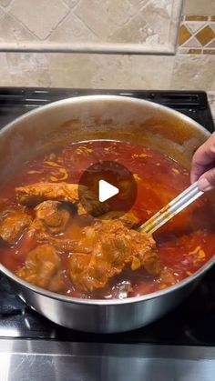 a person stirring food in a pot on the stove