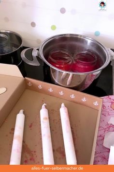 an open box with candles and other items on the stove top in front of it