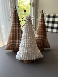 three small knitted christmas trees sitting on top of a table