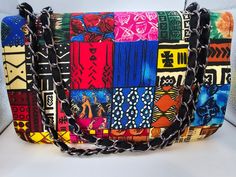 a multicolored handbag with chains hanging from it's front and sides