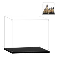 a glass display case with a castle in the middle and a black shelf below it