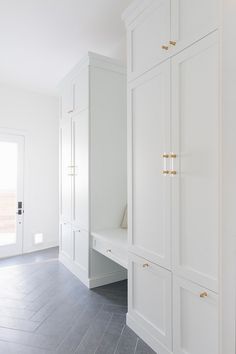 an empty room with white cabinets and wood flooring