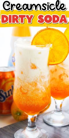 two glasses filled with orange soda sitting on top of a table