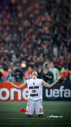 a man standing on top of a field with his arms outstretched in front of him