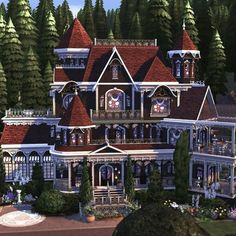 a large victorian style house in the middle of some trees