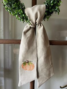 a burlap bag with an orange on it hanging from a wooden door handle