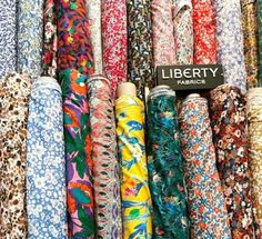 liberty fabrics are on display for sale at the store, with colorful patterns and colors