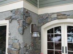 a red fire hydrant sitting in front of a stone building