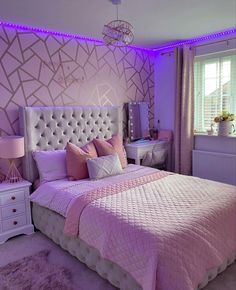 a bedroom decorated in pink and white with purple lighting