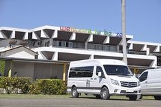 two white vans parked in front of an apartment building