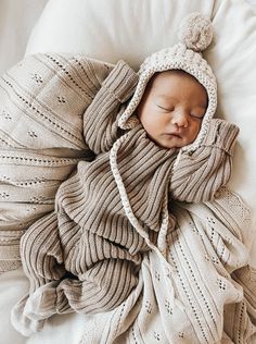 a newborn baby wrapped in a blanket and wearing a hat