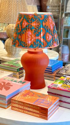 a lamp sitting on top of a table next to some books and lampshade