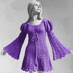 a woman in a crocheted dress is standing with her hands on her hips