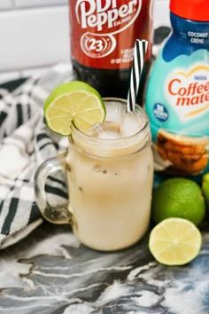 two bottles of coffee mate and limes on a marble table with a striped towel