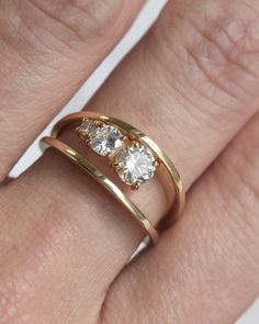 a woman's gold ring with two diamonds on it