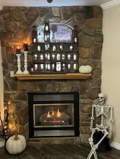 a skeleton sitting in front of a fireplace with halloween decorations on it's mantle