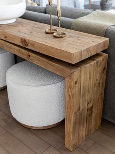 a wooden table sitting on top of a hard wood floor next to a gray couch