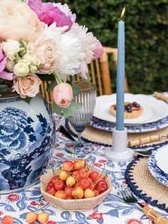 a table topped with plates and vases filled with flowers