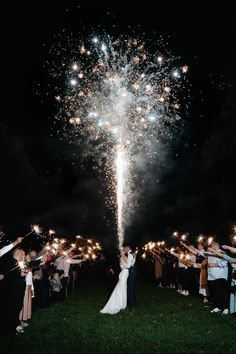 the bride and groom are surrounded by sparklers