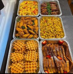 several trays of different types of waffles and other food items on a table