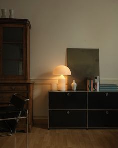 a room with a chair, lamp and bookshelf