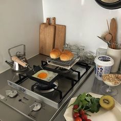 a stove top oven sitting inside of a kitchen next to plates and utensils