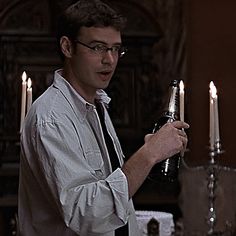 a man holding a candelabra with candles in the background