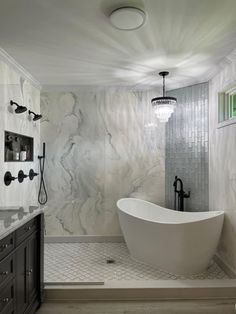 a bathroom with marble walls and flooring in white, gray and black colors is shown