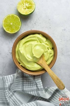 a wooden bowl filled with avocado on top of a white and gray towel