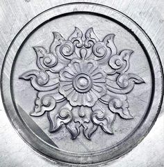 an ornate design on the side of a metal object in black and white photograph by michael strick