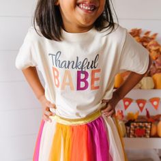 The Thankful Babe Thanksgiving Short Sleeve T-Shirt is a fun and festive t-shirt for kids celebrating Thanksgiving! Features: Shirt Color: Natural Graphic Color: Multicolor Material: 100% Cotton Features: Tagless inside neck label for an itch-free wear Fit: Toddler Unisex; True to Size Care: Machine washable, tumble dry low, wash with like colors Each t-shirt is hand pressed with love using baby and child safe inks. Kids Holiday Gifts, Sleepwear Dress, Boy Accessories, Kids Health, Holidays With Kids, Shoes Booties, Short Rompers, Sweater And Shorts, Kids Safe