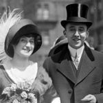 an old black and white photo of a man and woman dressed in fancy clothing, hats and furs