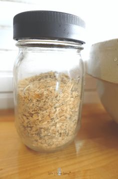 a glass jar filled with oats on top of a wooden table