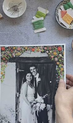 a couple is posing for a photo in front of some plates and bowls on the table