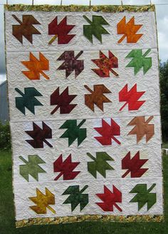 a quilted wall hanging in the grass with an arrow design on it's side