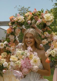 two women in dresses holding bouquets of flowers