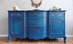 a blue painted dresser with gold trim