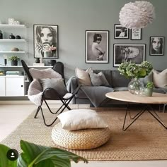 a living room with grey walls and pictures on the wall above the gray couches