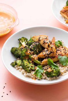 two white plates with chicken and broccoli on them