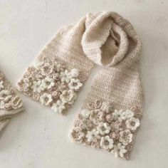 two knitted mittens and gloves on a white surface