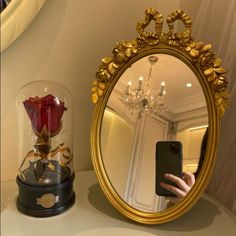 a person taking a selfie in front of a mirror with a rose on it