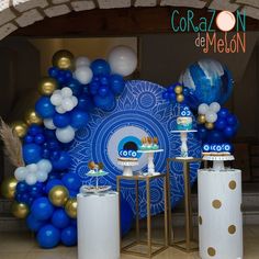 blue and white balloons are on display in front of a wall