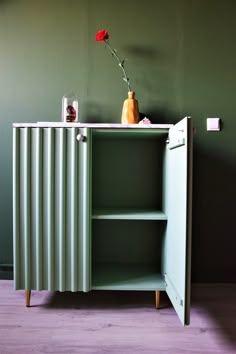 a green cabinet with a flower in it